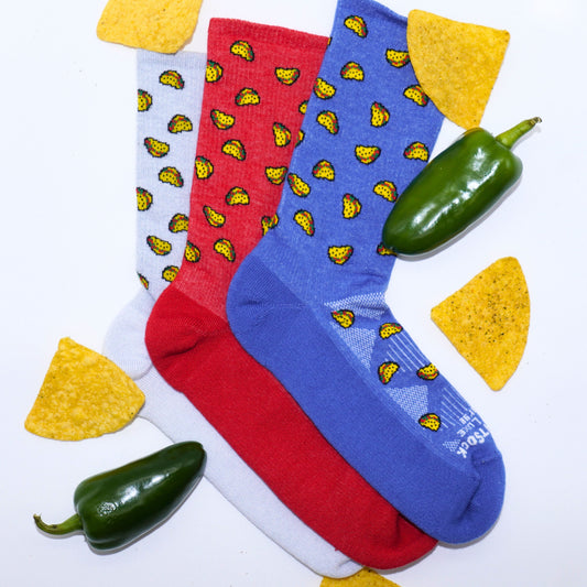 Run Luxe taco socks layed out with chips and jalapenos.