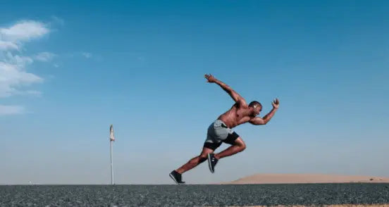 man running on pavement against a clear sky background