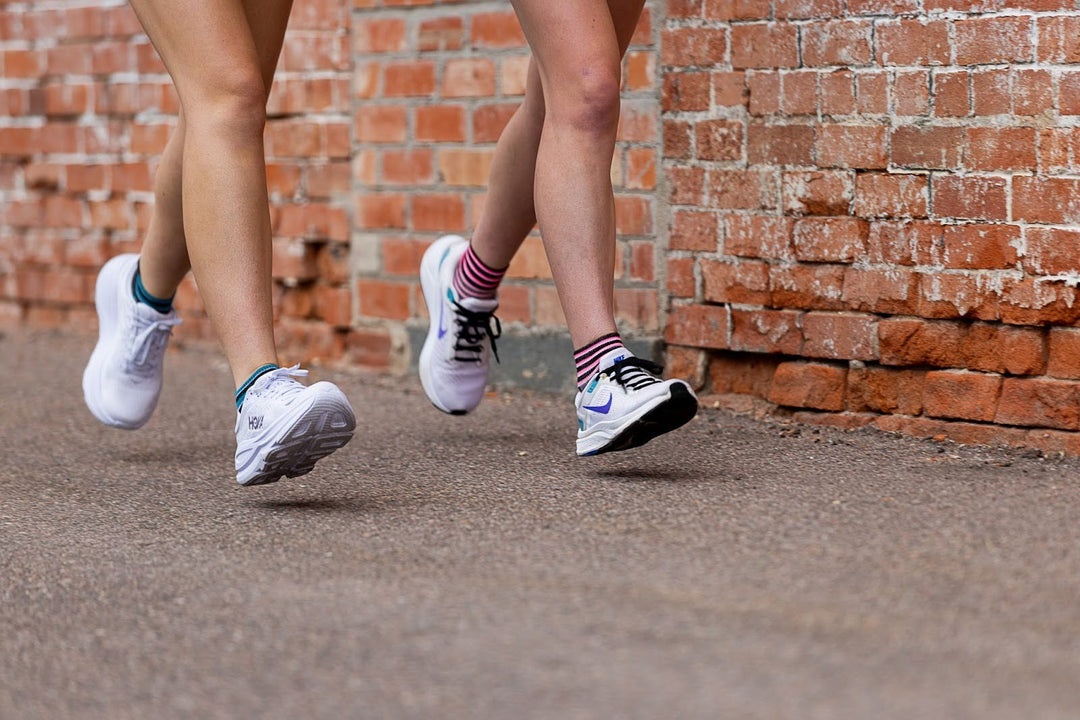two people running with image from the leg down of their white shoes and colorful socks