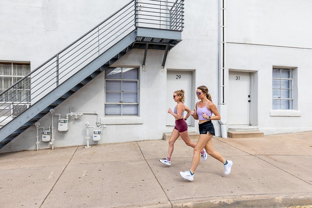 two women running on sidewalk