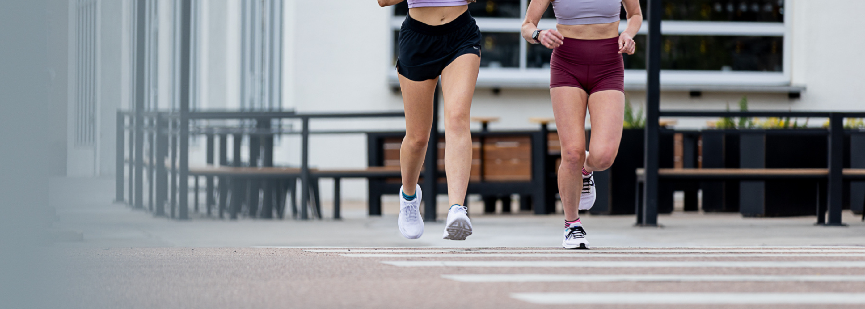 Two people running across a street wearing Wrightsock Running Socks.