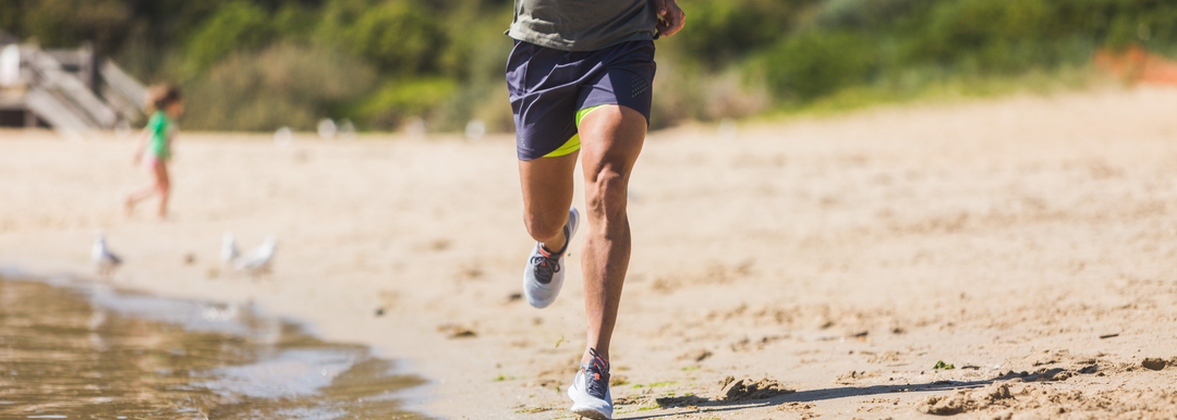 A person running on a beach and wearing Wrightsock Single Layer Lo Quarter Socks.