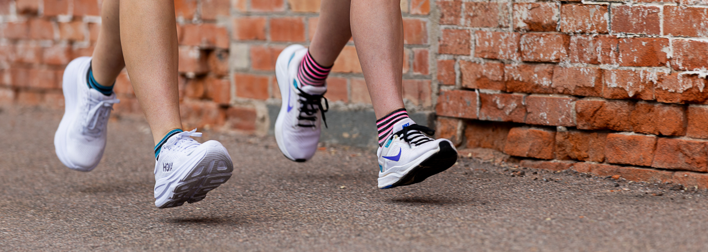 Runners wearing white sneakers and colorful anti-friction socks